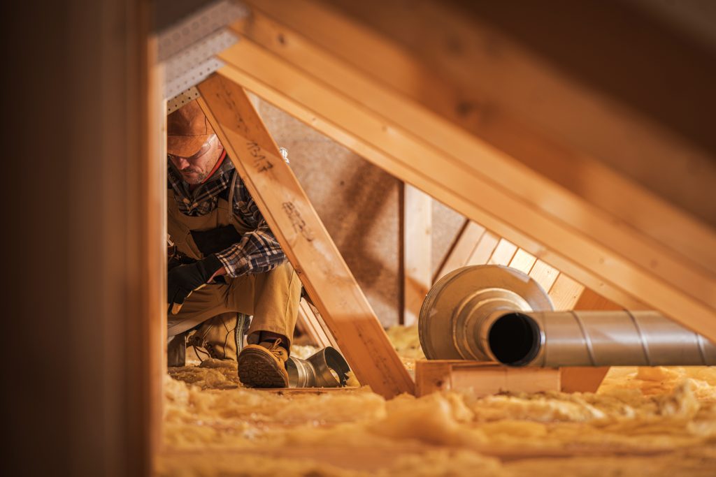 Worker completing an attic insulation inspection in London, Ontario